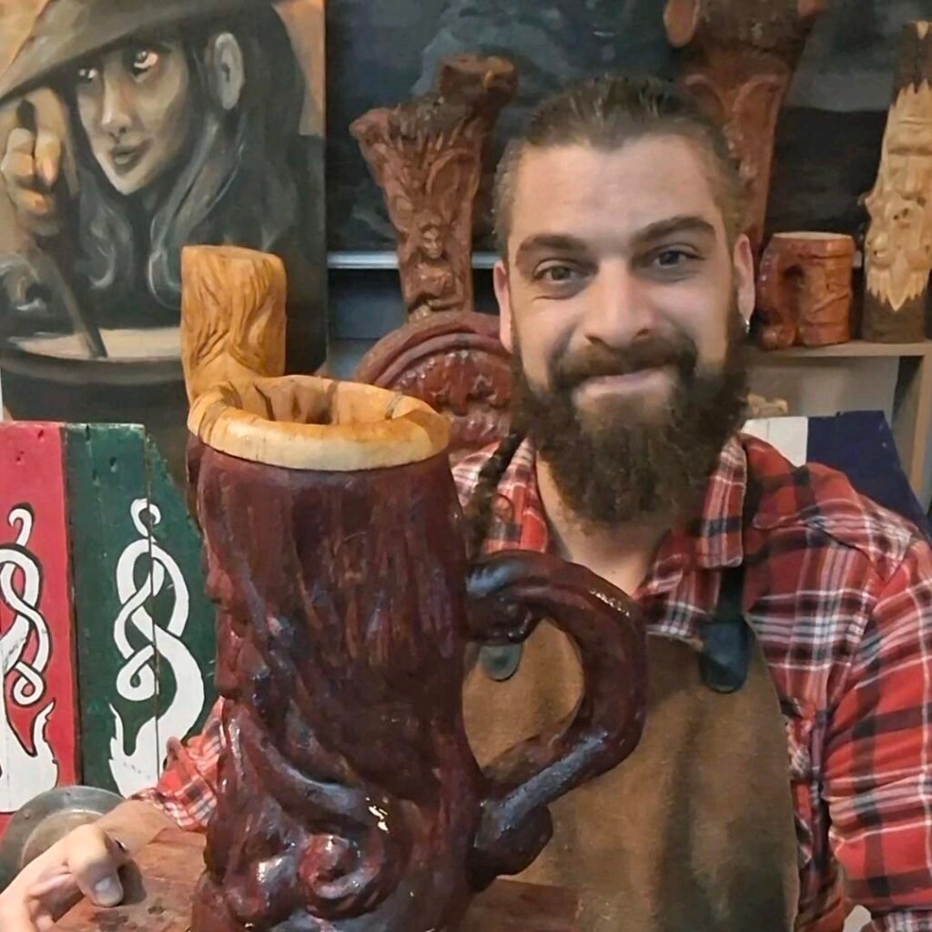 Hombre con barba y camisa de cuadros junto a una jarra de madera