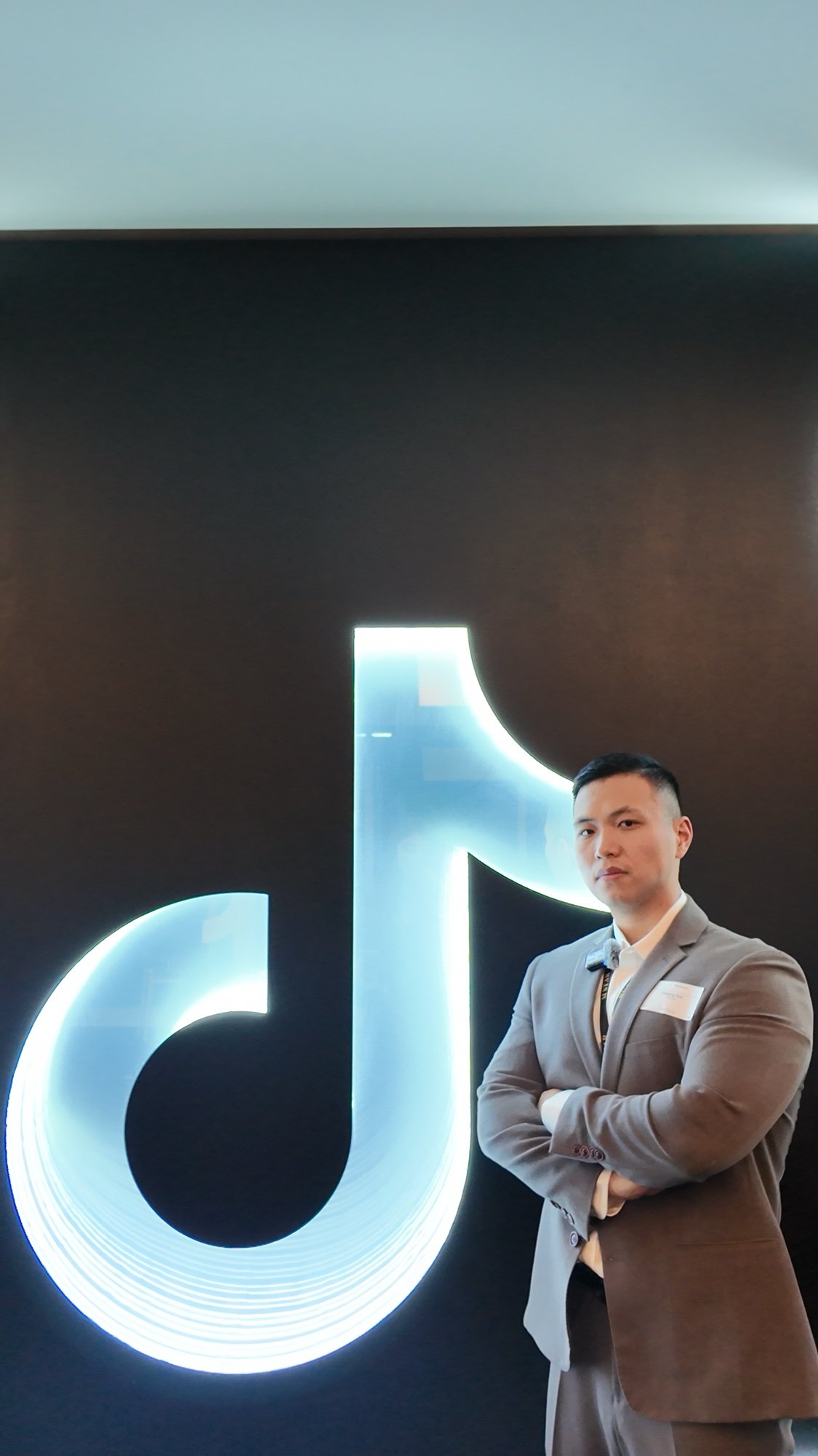 Representante del equipo de M STAR AGENCY junto al logotipo iluminado de TikTok.